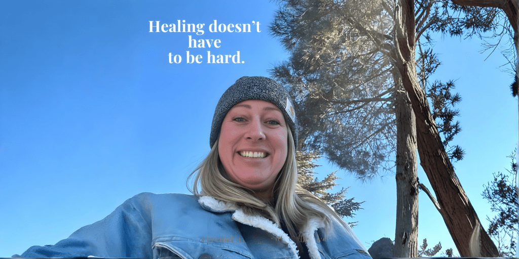 Smiling woman outdoors under blue sky with trees, text reads “Healing doesn’t have to be hard.” promoting natural wellness.