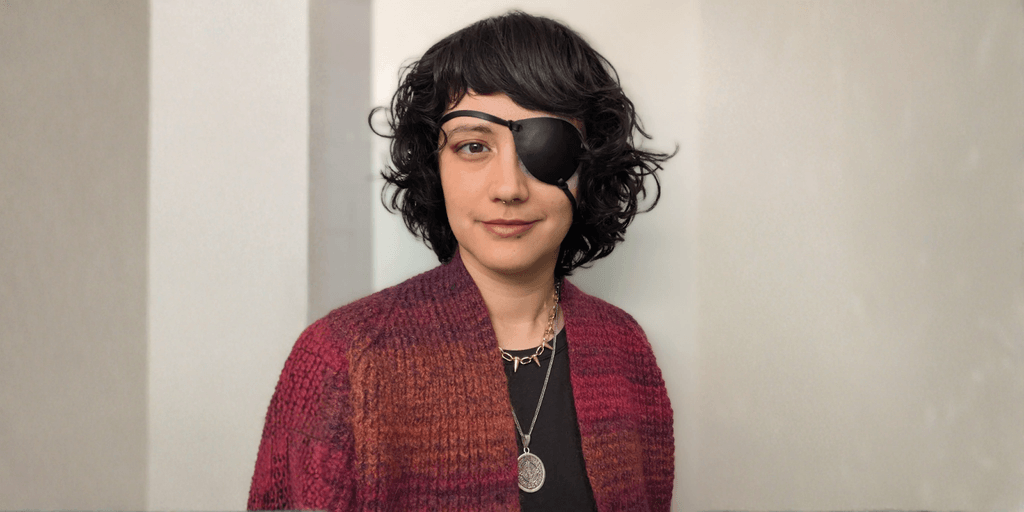 Abigail Roscoe, a disabled artist, wearing an eye patch, showcasing her unique style and resilience.