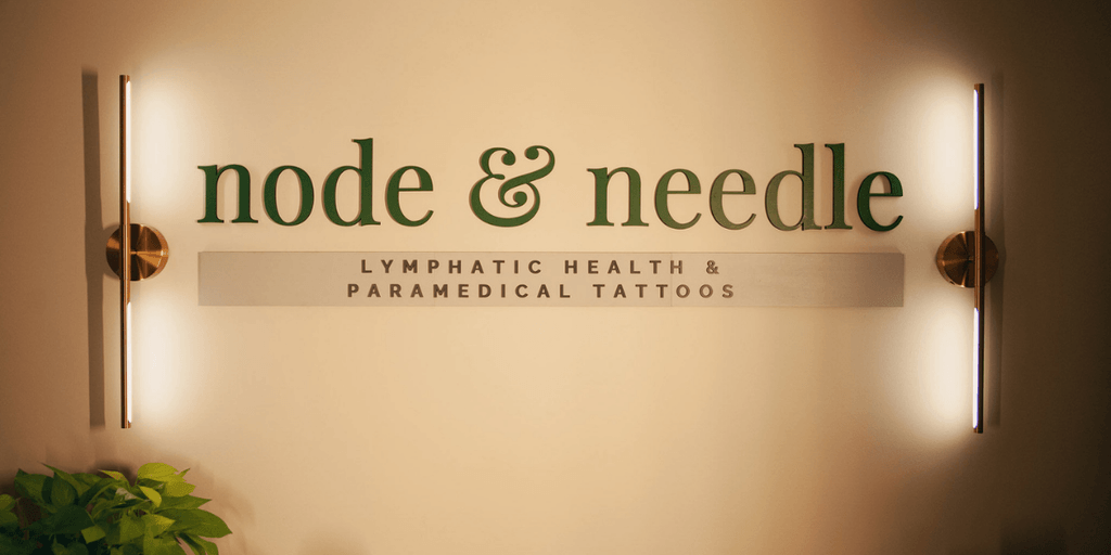 Signage for "node & needle," a wellness studio offering lymphatic health and paramedical tattoo services for healing and empowerment.