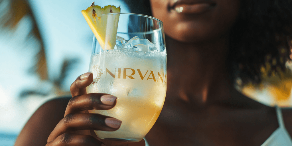 “Woman holding branded Nirvana cocktail, showcasing the company’s premium wellness-focused RTD product and luxury, refreshing lifestyle experience in a tropical setting.”