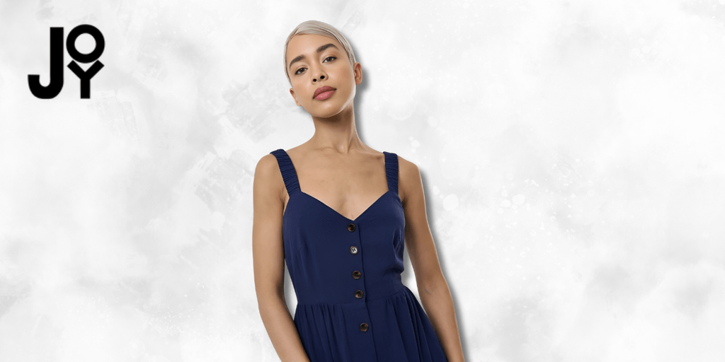 "Fashionable model wearing a navy blue dress with button details, posing confidently with a clean, bright background, promoting joy and confidence in style."