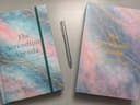 Two editions of The Serendipity Agenda displayed beside a silver pen.