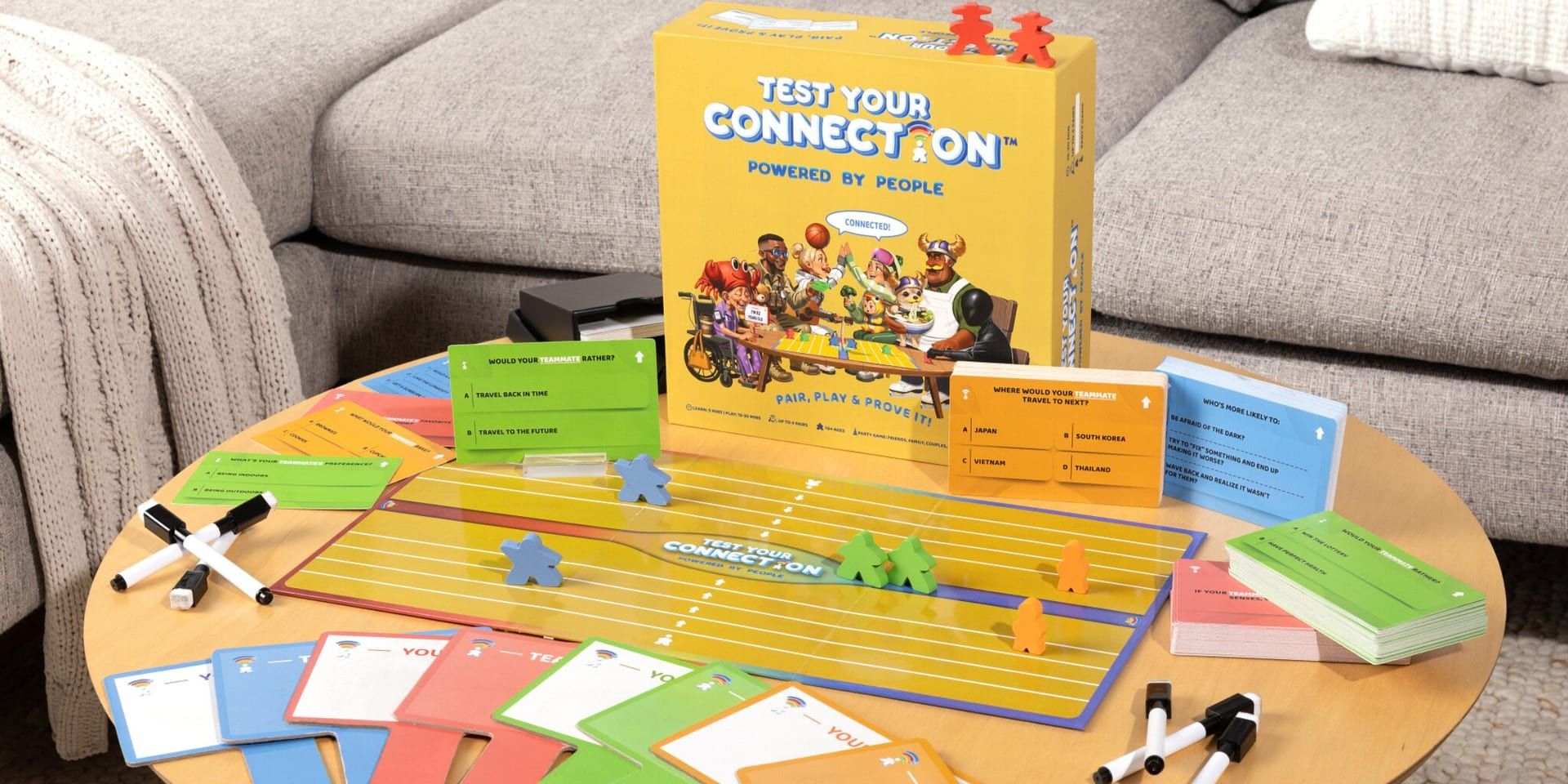 Test Your Connection board game with cards, markers, player pieces, and game box displayed on a coffee table.
