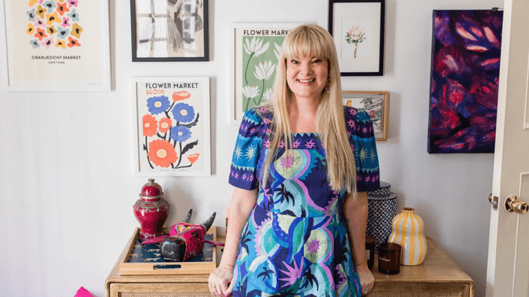 Nikki Smit standing in front of colorful artwork, promoting emotional resilience and mental wellness.