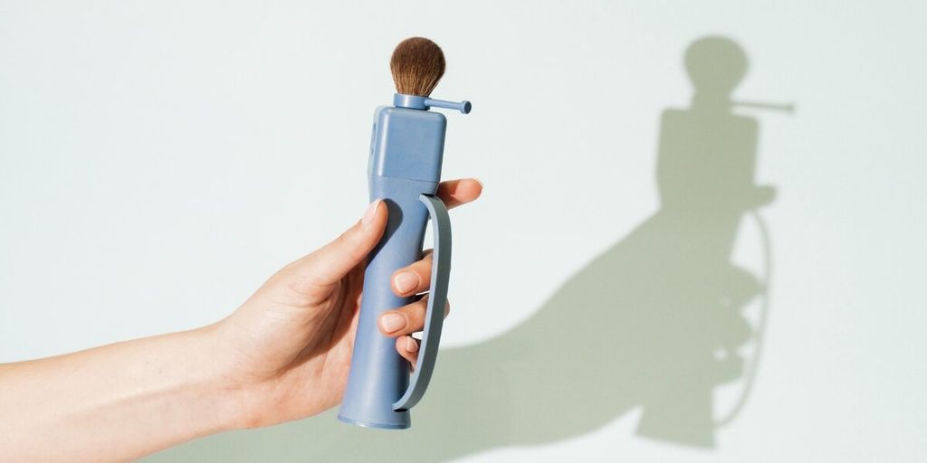 Hand holding Flexxi Beauty’s 4-in-1 interchangeable makeup brush, highlighting ergonomic design and brush head.