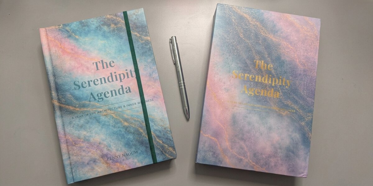 Two editions of The Serendipity Agenda displayed beside a silver pen.