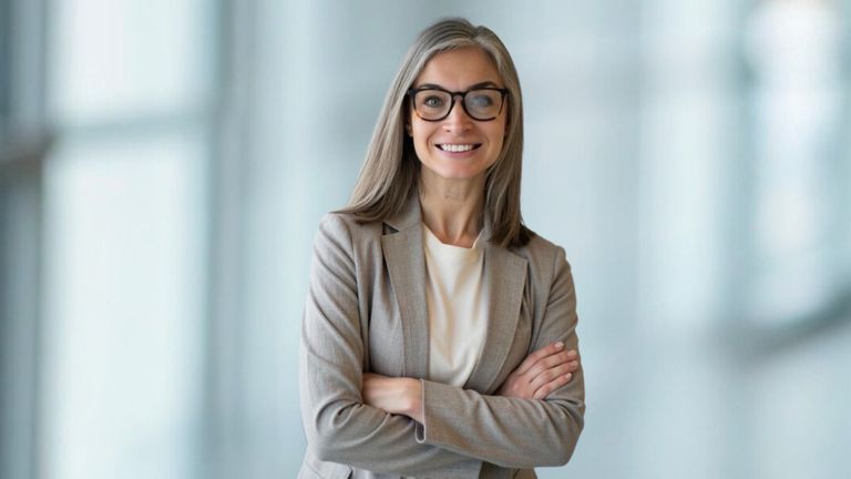 Dr. Dorota Novitskie, a forensic psychologist with 20 years of experience, stands confidently with arms crossed in a professional setting.