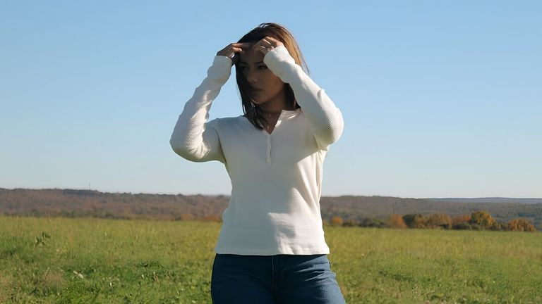 Hailey Howell models Hails denim outdoors, blending individuality, culture, and creative storytelling against a peaceful natural landscape and open sky.