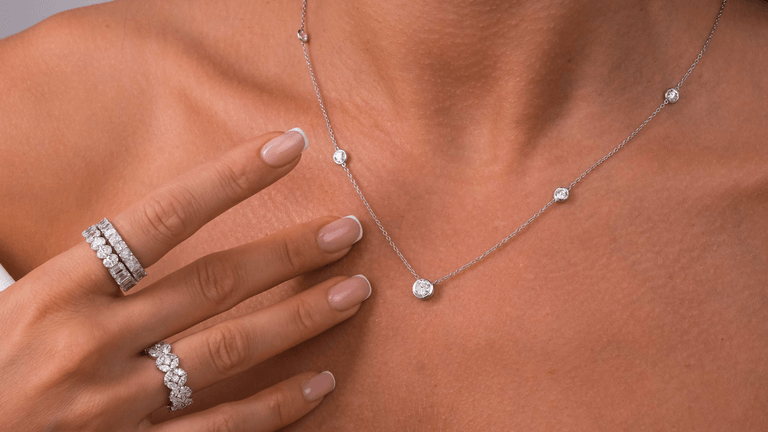 Elegant diamond jewelry including a necklace and rings, featuring sparkling stones set in white metal, showcasing timeless craftsmanship