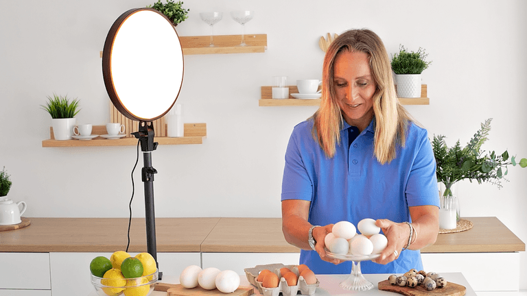 Dr. Sara Pugh holds eggs in a well-lit kitchen, highlighting her focus on energy, light, and natural health.