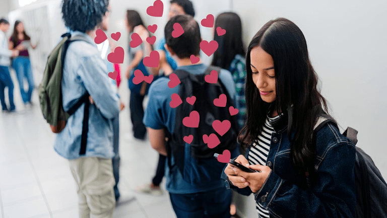 Person using a smartphone while others socialize nearby, illustrating modern online dating.