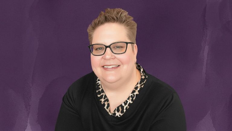 Portrait of self-care mentor Mickey Forsyth smiling against a purple background.