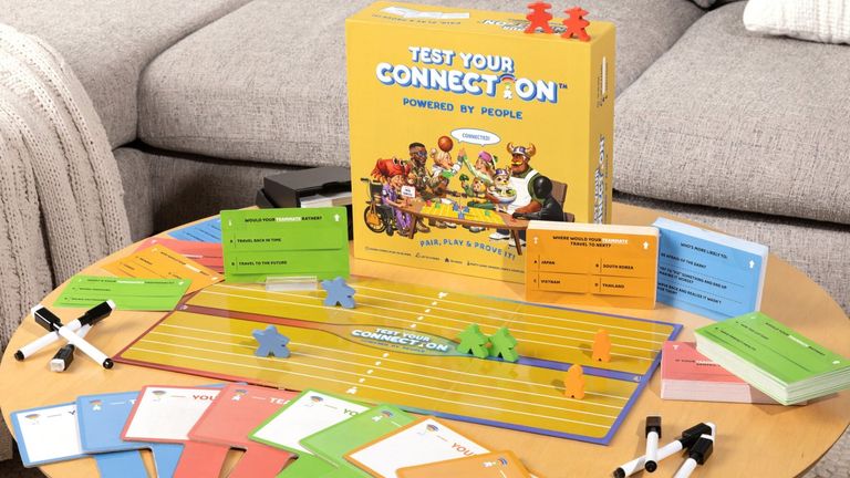 Test Your Connection board game with cards, markers, player pieces, and game box displayed on a coffee table.