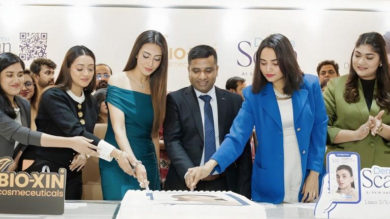 a team cutting a cake to celebrate the launch of Bio-Xin's DermaScan AI Skin Analyzer.