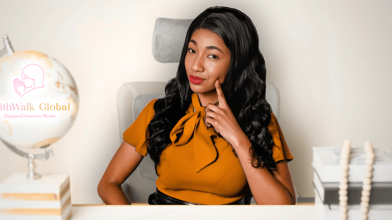 Woman in mustard blouse sitting confidently at desk with FaithWalk Global logo in background.