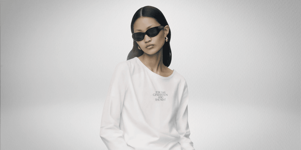 Model wearing FCCW’s AI-designed white sweatshirt with sunglasses; text on shirt reads “For This Generation and the Next.”