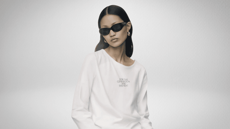 Model wearing FCCW’s AI-designed white sweatshirt with sunglasses; text on shirt reads “For This Generation and the Next.”