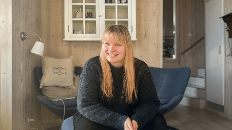 Mia Meincke Nisted, founder of Meincke Nisted, smiling warmly in a cozy setting, representing her somatic-based coaching for high-functioning women.