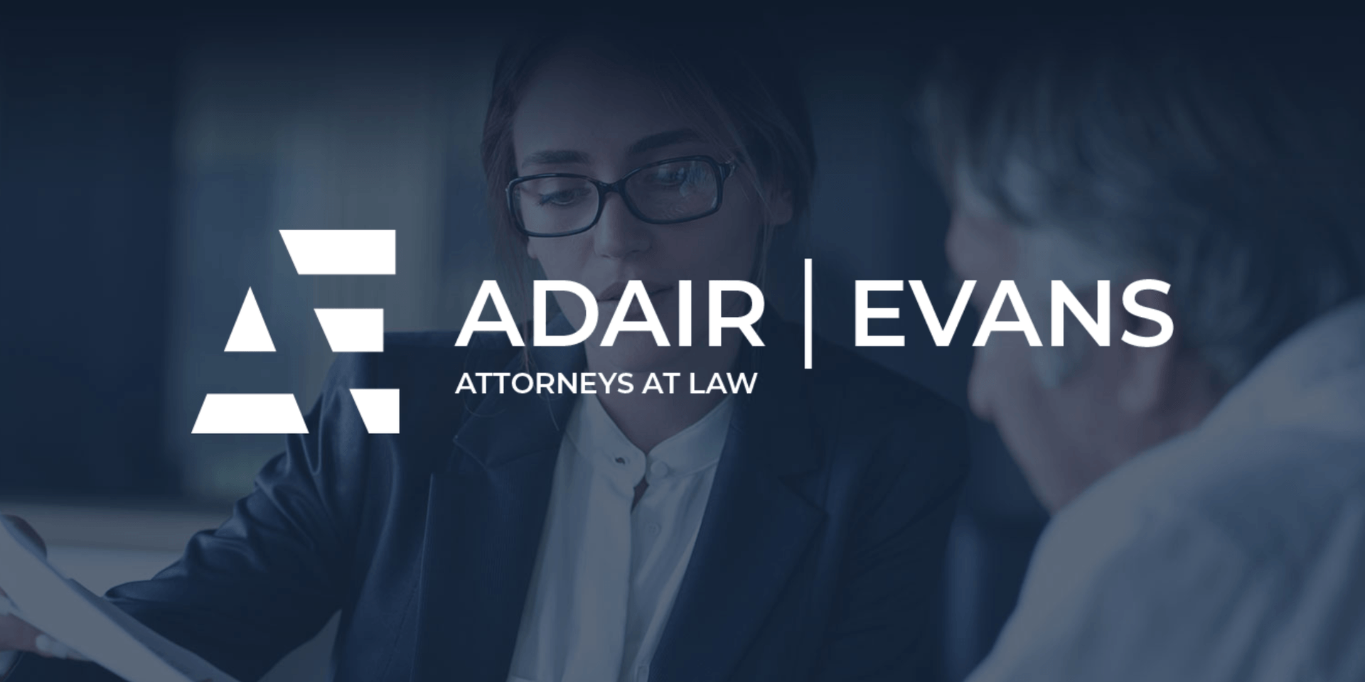 Lawyers discussing a case with the Adair Evans logo prominently displayed