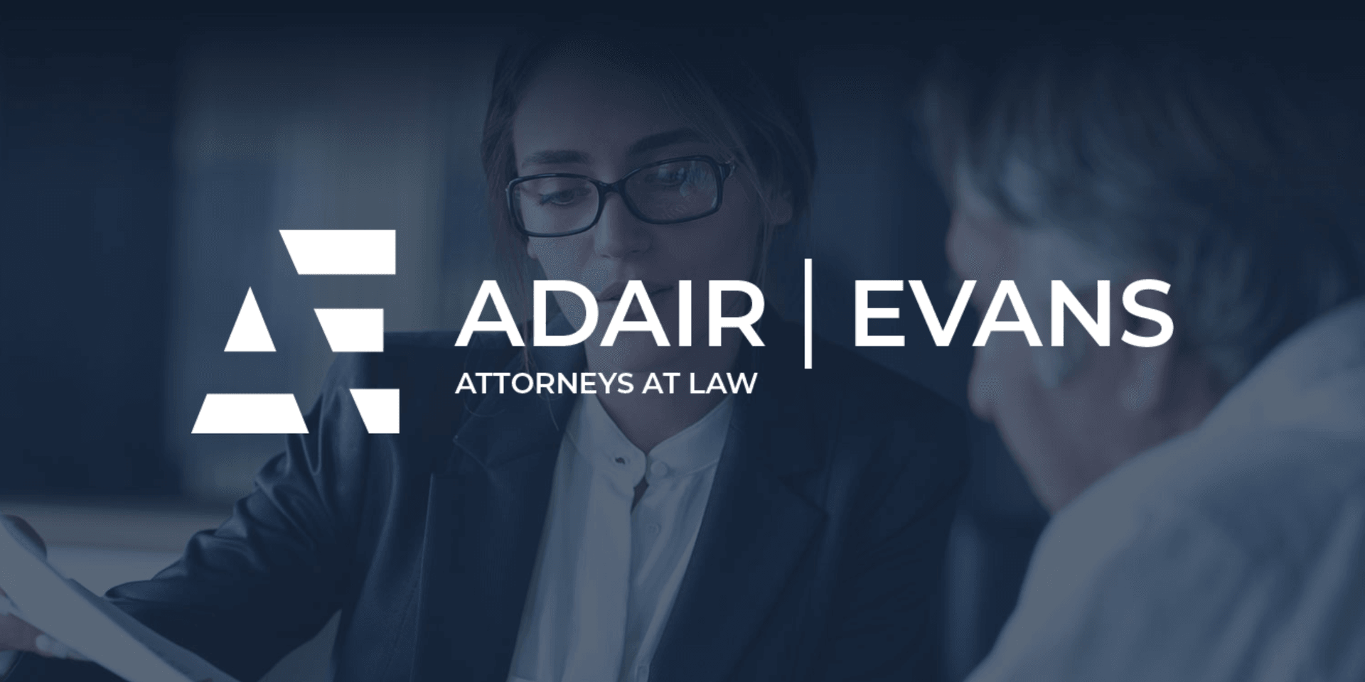 Lawyers discussing a case with the Adair Evans logo prominently displayed