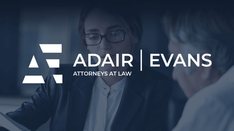Lawyers discussing a case with the Adair Evans logo prominently displayed