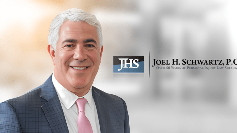Professional headshot of a man in a suit with a logo for a law firm