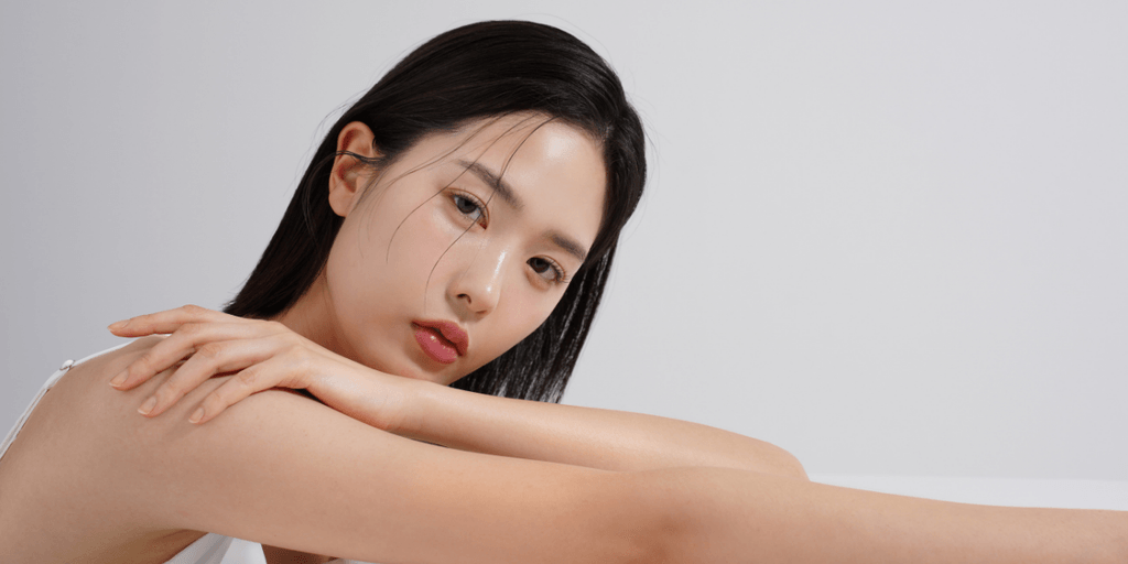 A young woman resting her arms on a surface, gazing thoughtfully at the camera