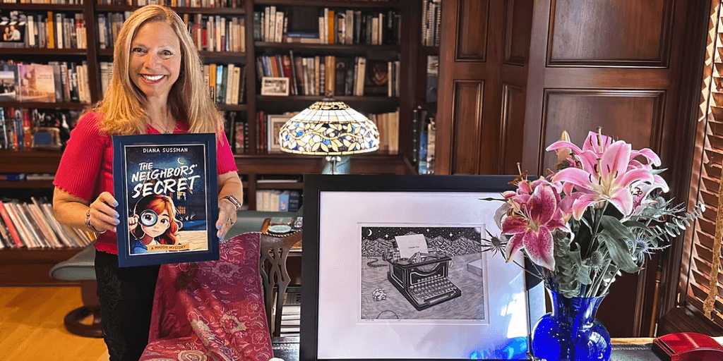 Woman holding a book titled "The Neighbor's Secret" beside flowers and a framed drawing