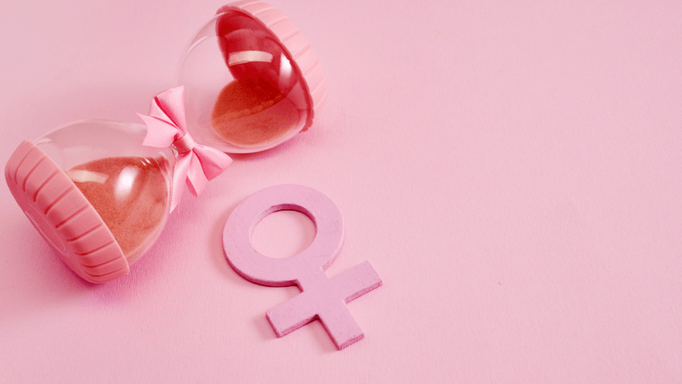Pink hourglass with a bow next to a pink female gender symbol