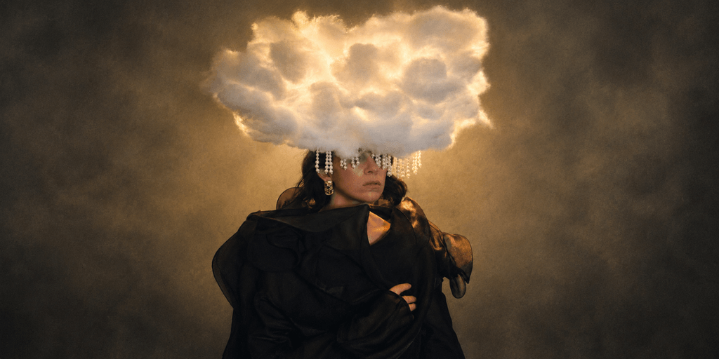 A figure with a cloud-shaped headpiece adorned with crystals against a dramatic background