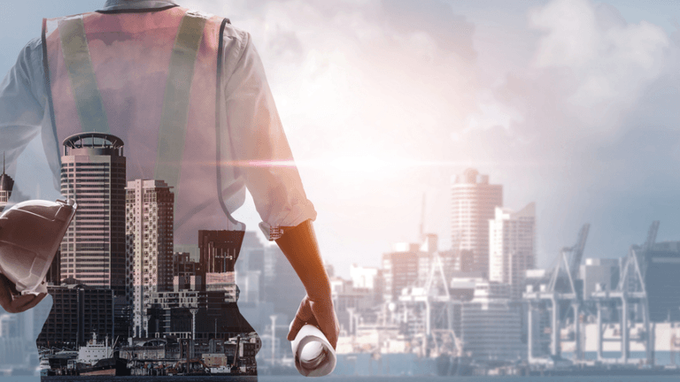 Silhouette of a construction worker standing with a city skyline in the background