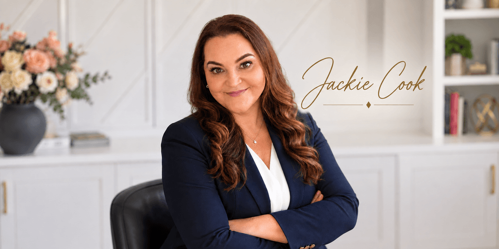 Professional woman in a blazer sitting with arms crossed, smiling at the camera