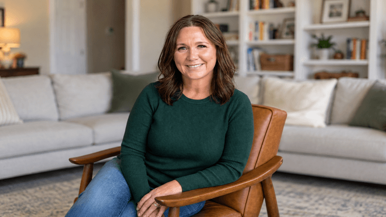 Smiling woman in green sweater sitting in a cozy living room chair