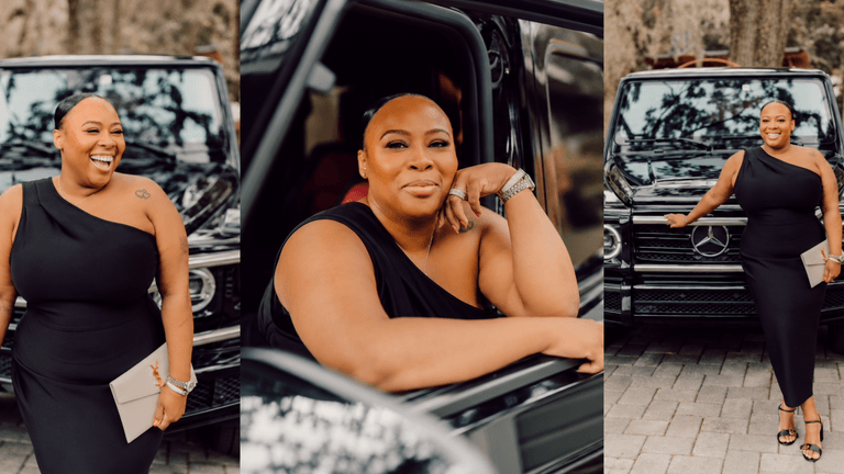 Woman in elegant black dress poses by luxury car, smiling confidently.