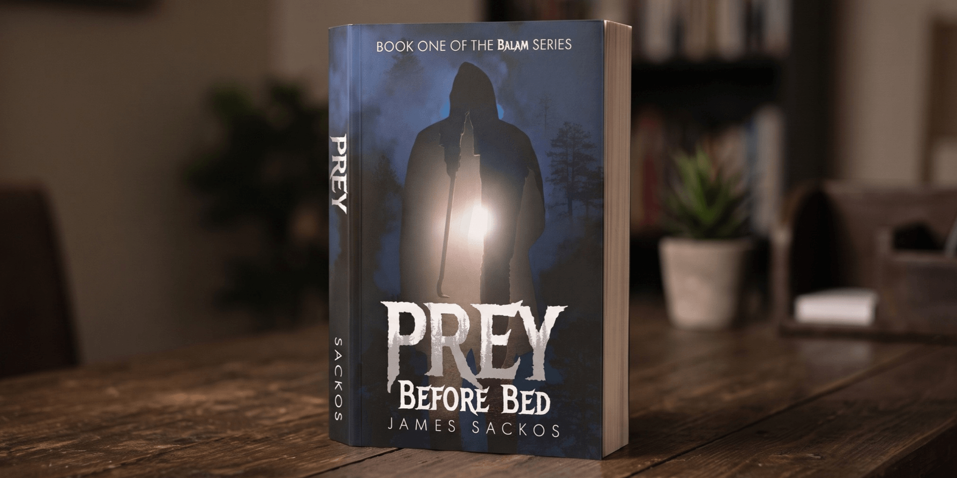 A book titled "Prey Before Bed" by James Sackos displayed on a wooden surface