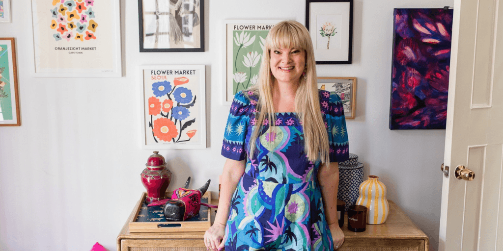 Nikki Smit standing in front of colorful artwork, promoting emotional resilience and mental wellness.