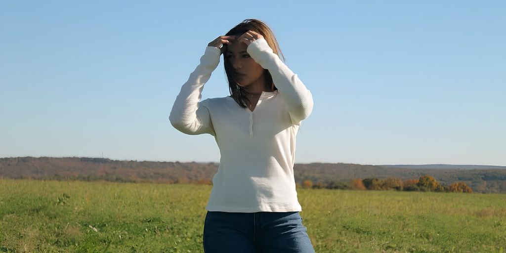 Hailey Howell models Hails denim outdoors, blending individuality, culture, and creative storytelling against a peaceful natural landscape and open sky.
