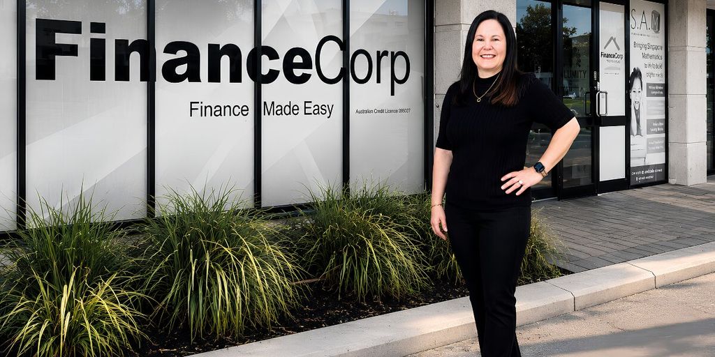 Tracey Franco standing outside FinanceCorp office with company signage visible in the background.