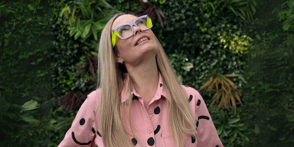 Emmaline McAndrew smiling in pink shirt, representing The Slow Businesswoman, a business platform for women with chronic illness.