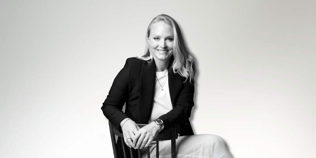Milena Dold, founder of IRALIS, confidently seated and smiling, embodies the empowerment and luxury of self-purchased diamonds, symbolizing independence, achievement, and a redefined approach to personal milestones in the jewelry industry.