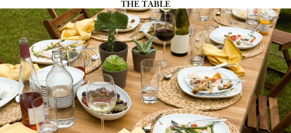 An inviting dining table with plants, glassware, and plates, symbolizing connection and community, perfect for Sandra's faith-driven program.