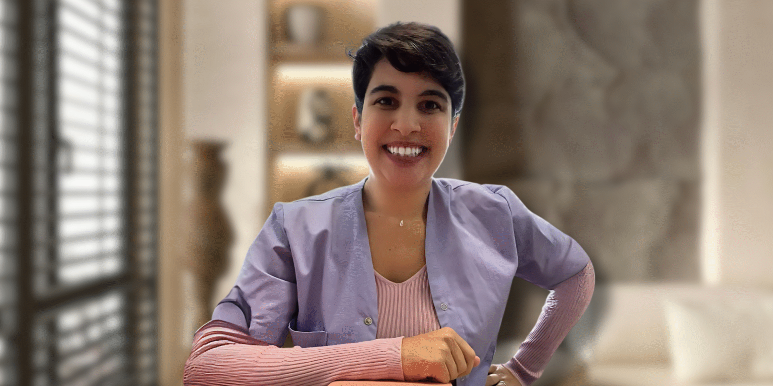 Amalia Pavlidi, founder of Alternative Therapies B.V., smiling in her professional attire, representing the holistic wellness and natural skincare services of her company in the Netherlands.
