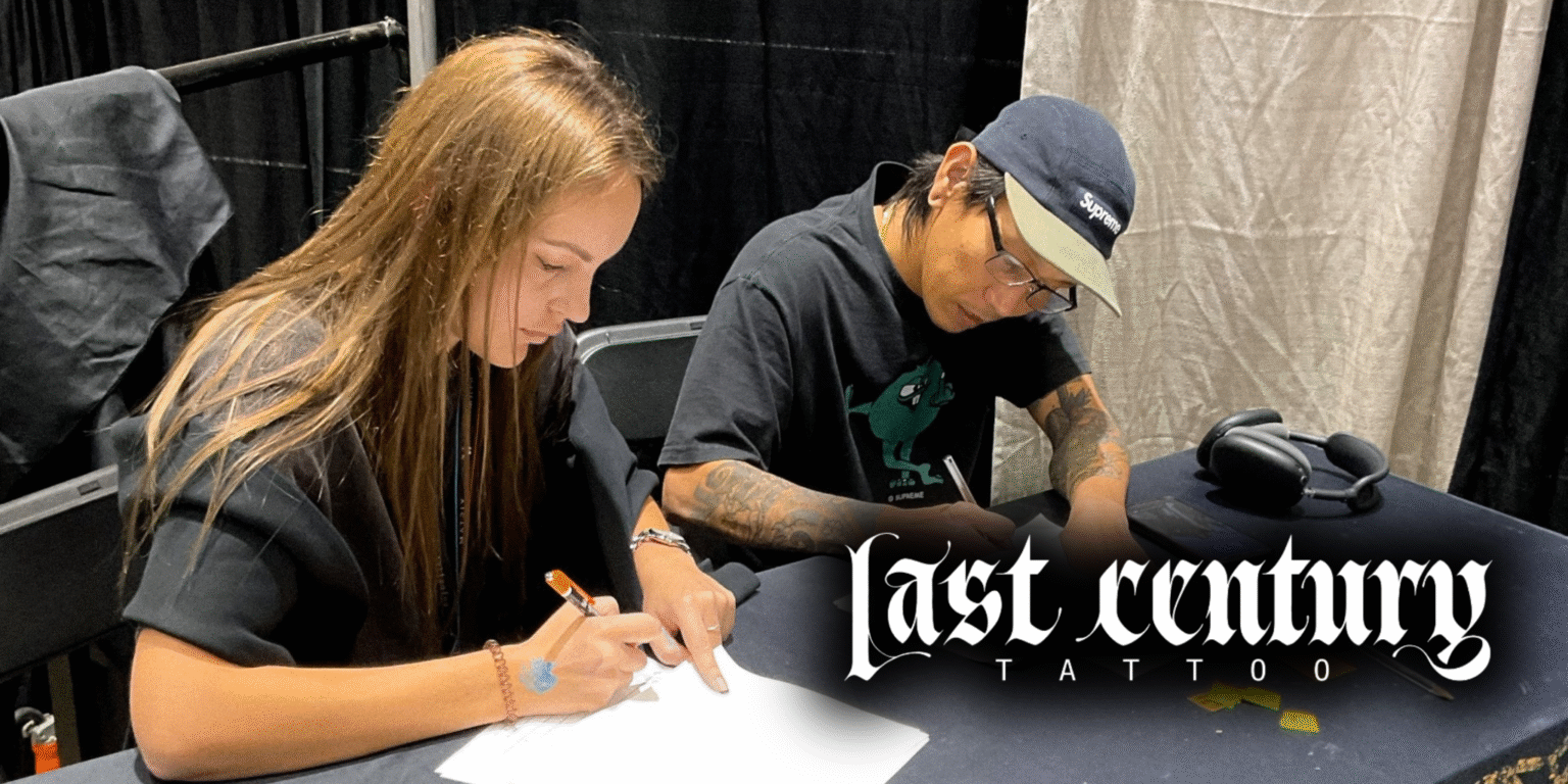 Tattoo artist sketching design with client at Last Century Tattoo studio.