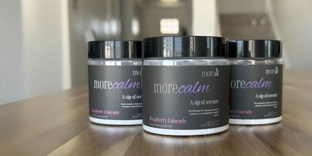 Two containers of morecalm Raspberry Limeade calming drink mix on a wooden surface, with the label 'A sip of serenity' visible.