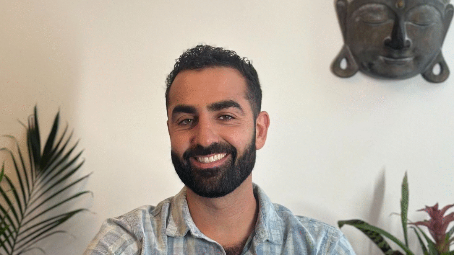 Mark Mostaed, the creator of The Shadow Code™, smiles confidently in a calming environment, embodying his role as a guide helping women break free from toxic emotional patterns and reclaim their self-worth through neuroscience-backed somatic healing.