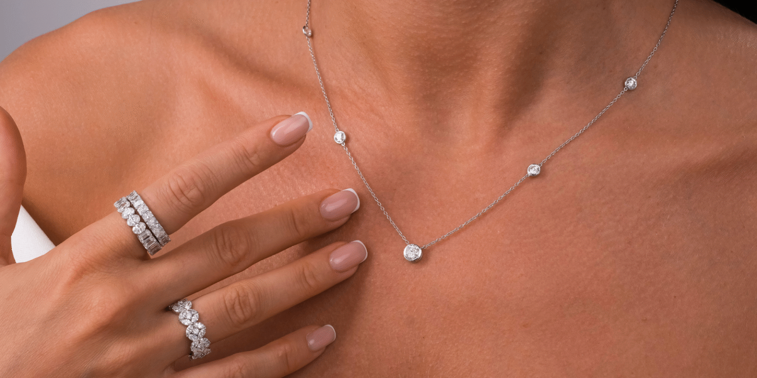 Elegant diamond jewelry including a necklace and rings, featuring sparkling stones set in white metal, showcasing timeless craftsmanship