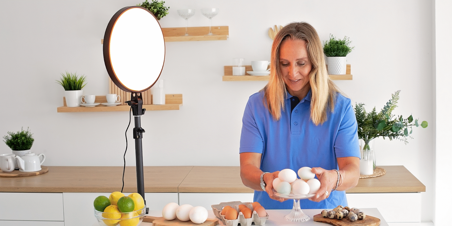 Dr. Sara Pugh holds eggs in a well-lit kitchen, highlighting her focus on energy, light, and natural health.