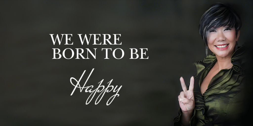 Smiling woman in green outfit flashing peace sign with text: "We Were Born to Be Happy."
