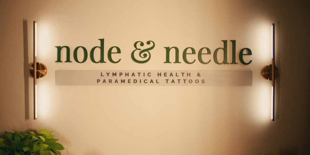 Signage for "node & needle," a wellness studio offering lymphatic health and paramedical tattoo services for healing and empowerment.