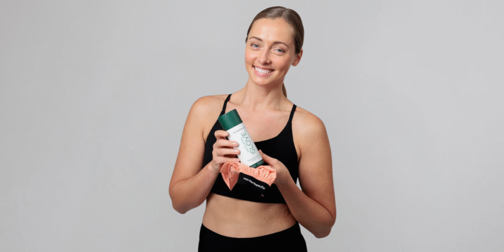 The “Best Exfoliating Glove” of 2025 Has Been Decided "Smiling woman in athletic wear holding the Nordenbeauty Turkish Silk Exfoliating Glove, promoting smooth, glowing skin."